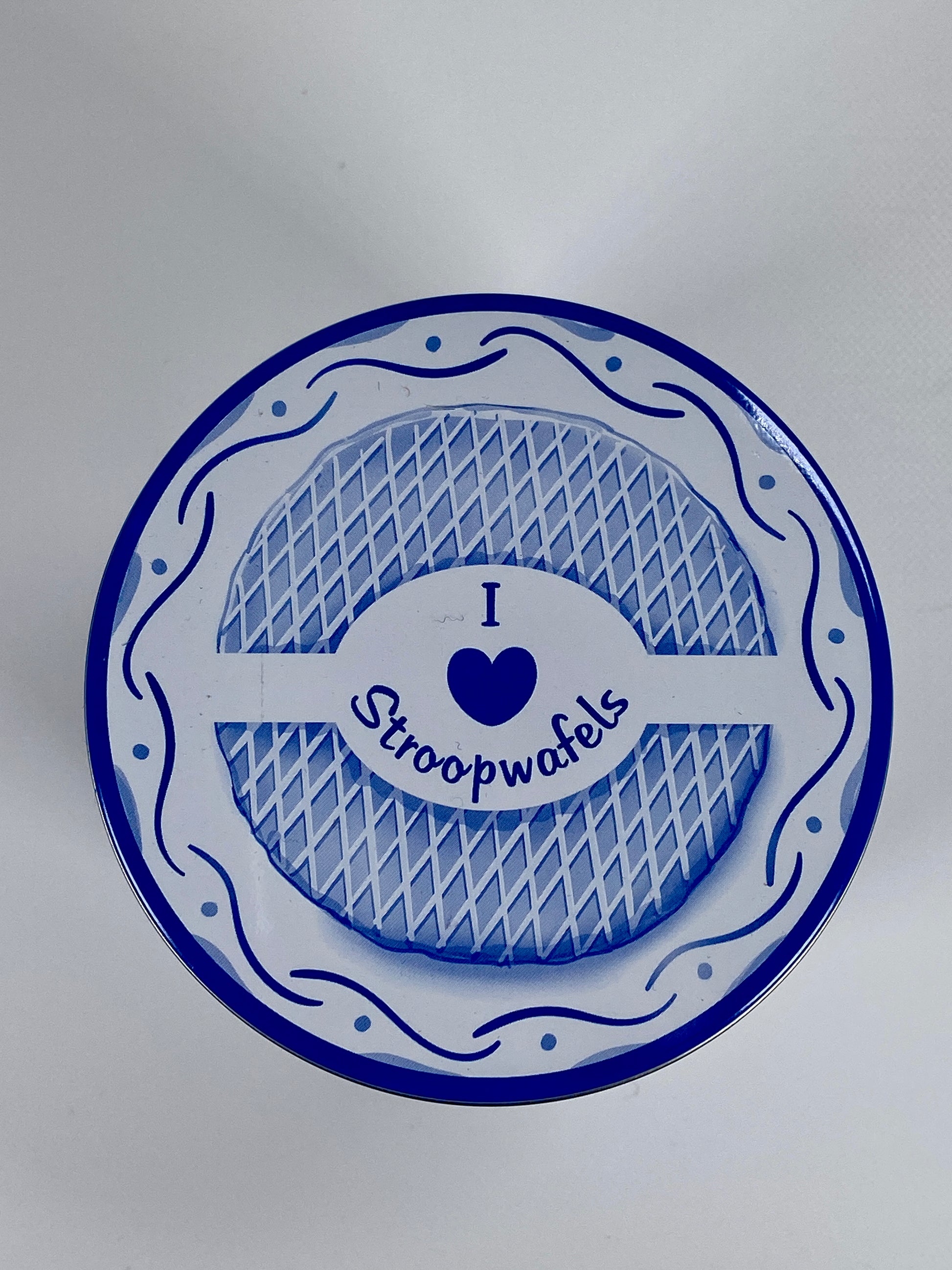 Top of a tin with Delft Blue pattern showing text ' I love stroopwafels' and blue heart - Big Bite Dutch Treats