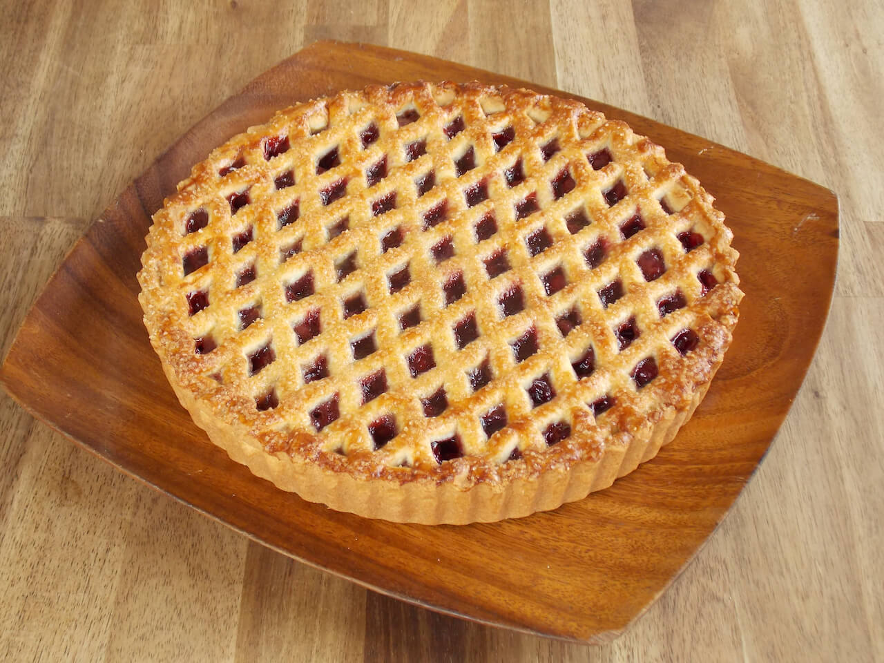 Linzer taart - Linzer fruit pie on wooden plate - Big Bite Dutch Treats